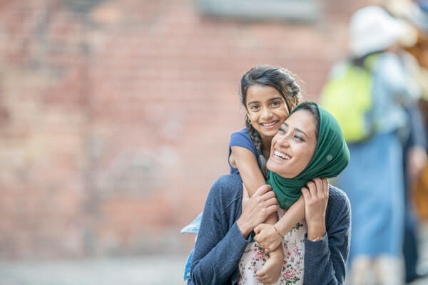 woman in burka holding small child lovingly